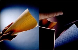 Manos sosteniendo una hoja de papel reciclado sobre fondo oscuro &mdash; El reciclaje de la madera